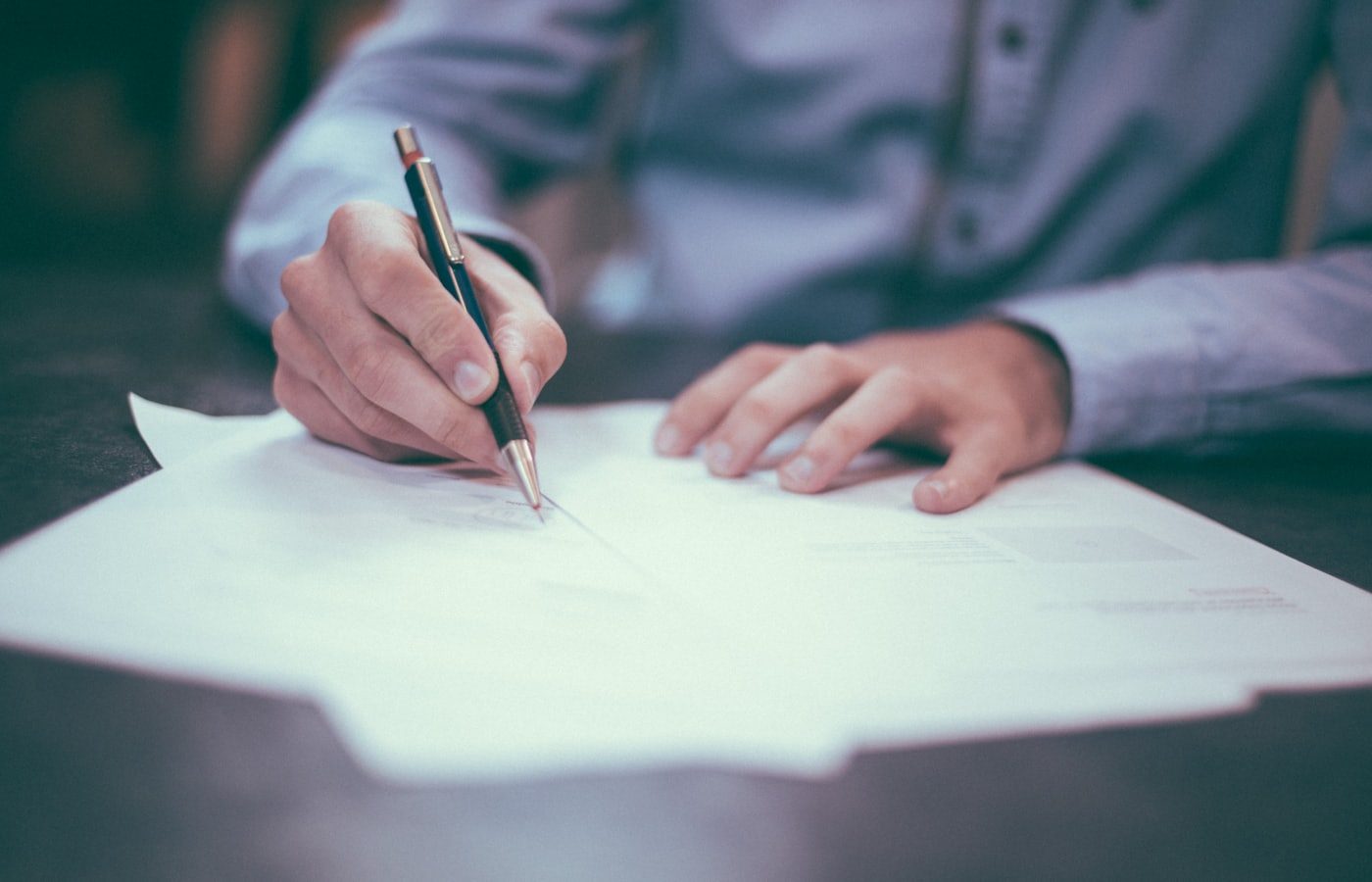 Hands writing on construction documents